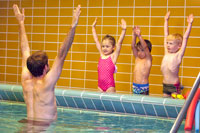 Kinder und Schwimmlehrer bei Trockenübungen