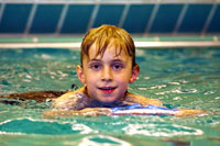 Junge im Wasser mit Schwimmbrett